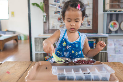 Cute little girl concentrated playing at kindergarten.