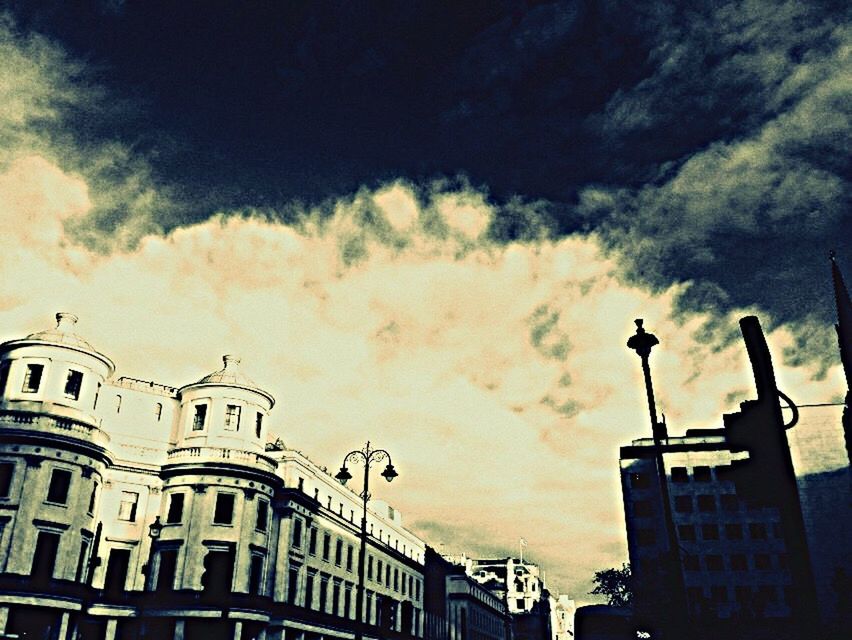 LOW ANGLE VIEW OF BUILDINGS AGAINST CLOUDY SKY