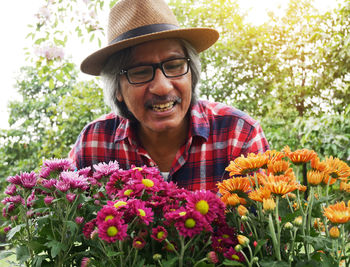 Portrait of smiling young woman with red flowers