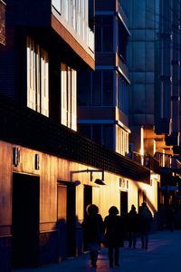 People walking on illuminated street at night