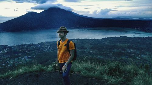 Full length of man standing on lake against mountains