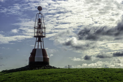 Low angle view of lighthouse on field against sky