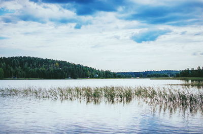 Scenic view of lake against cloudy sky