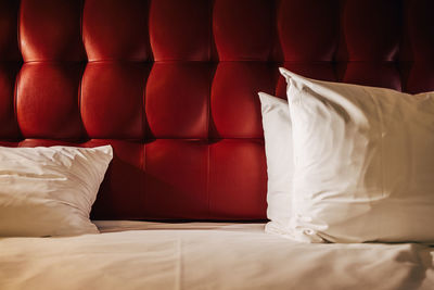 White pillows in front of red upholstered wall