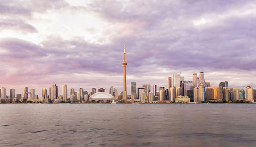 Modern buildings in city against cloudy sky