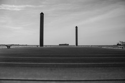 Columns and pier by sea against sky