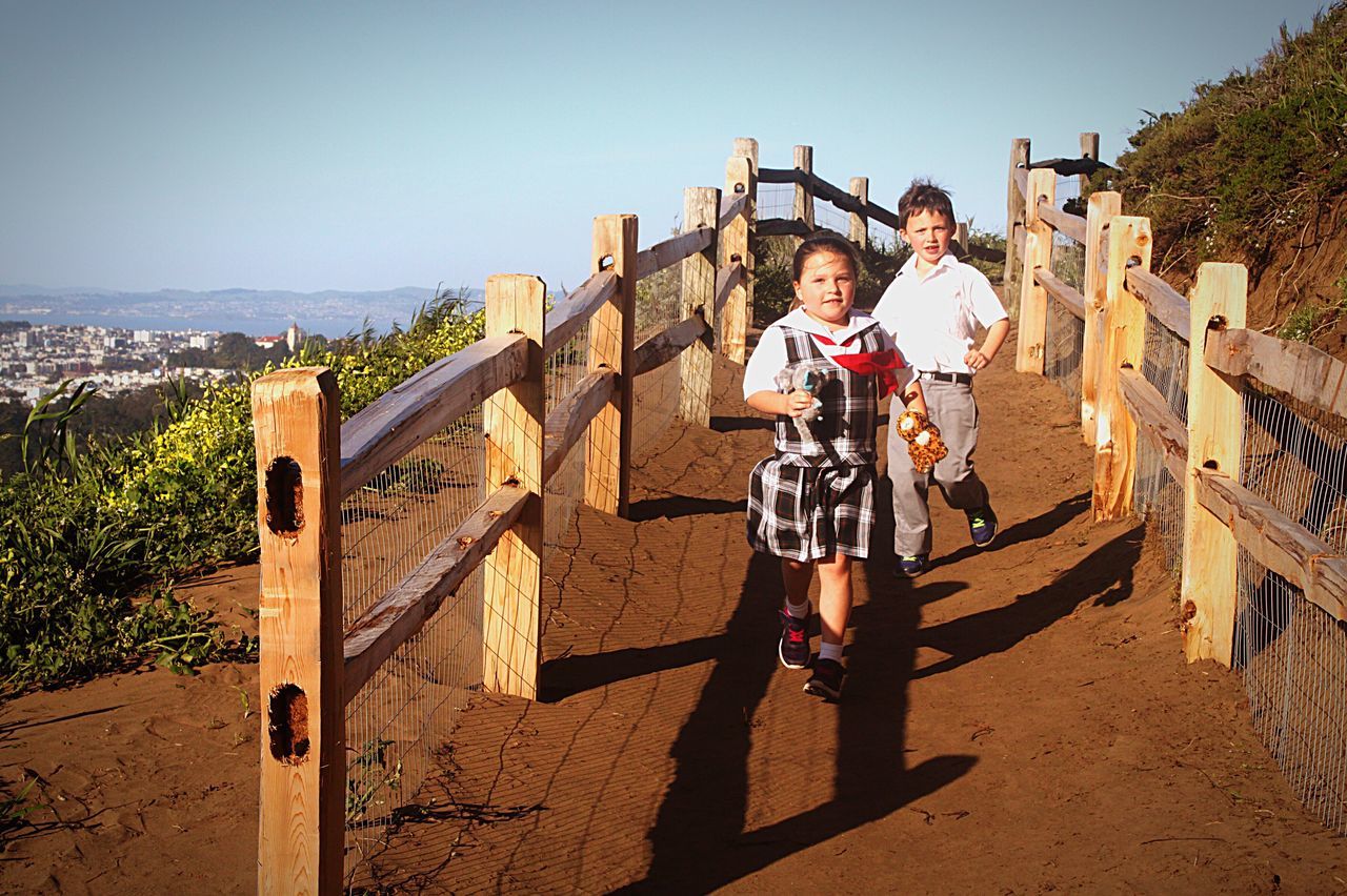 full length, sunlight, childhood, outdoors, boys, adventure, child, people, children only, two people, sky, city, day, togetherness, friendship, cityscape, adult