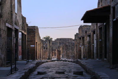 Footpath amidst buildings in city of pompeii ruins