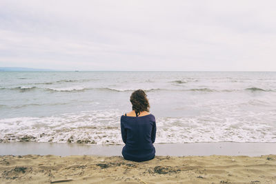 Rear view of woman looking at sea against sky