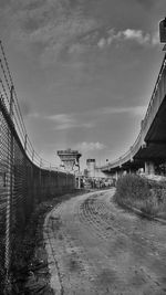 Road by bridge against sky in city