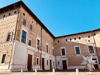 Low angle view of old building against clear blue sky