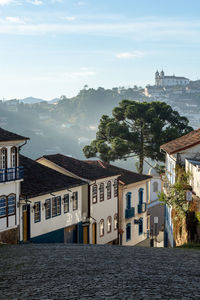 Houses by sea against sky in city