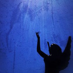 Young woman with arms raised at night