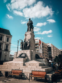 Low angle view of statue against buildings in city