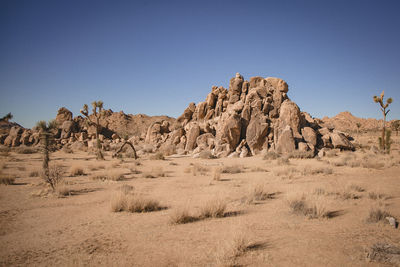 Rock formations in desert against clear blue sky