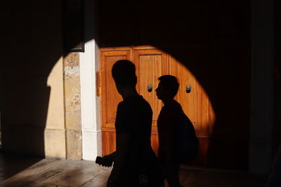 Silhouette people standing in corridor of building