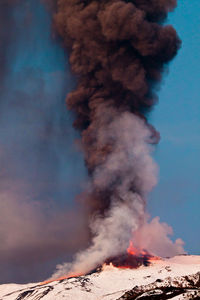 Low angle view of bonfire on mountain against sky