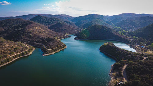 High angle view of river amidst mountains against sky