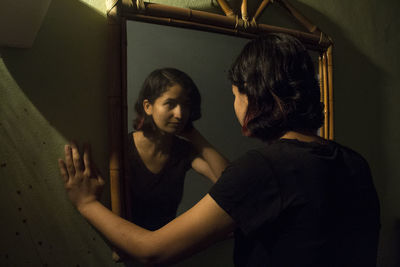 Reflection of woman in mirror at home