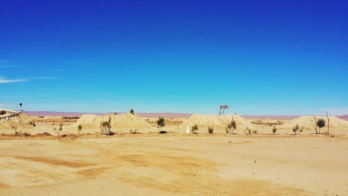 Scenic view of desert against clear blue sky