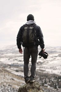 Rear view of man standing on rock