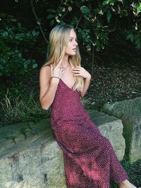 Woman sitting on retaining wall