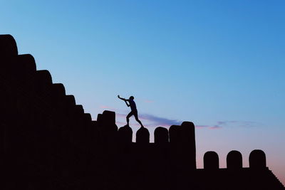 Low angle view of silhouette man against sky