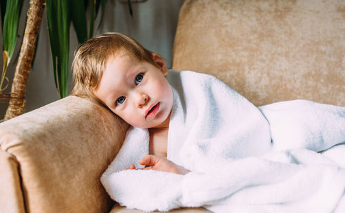 Portrait of cute baby lying on blanket at home
