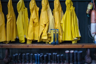 Yellow raincoats and rubber boots arranged outdoors