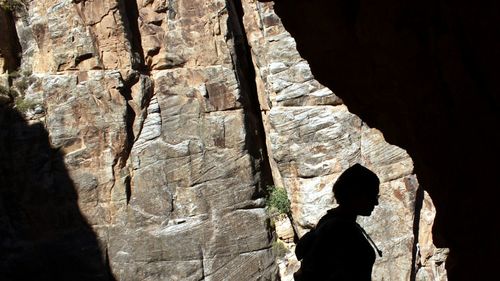 Silhouette woman standing on rock formation