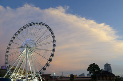 Low angle view of ferris wheel against sky at sunset