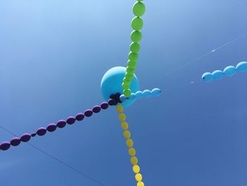 Low angle view of balloons against blue sky