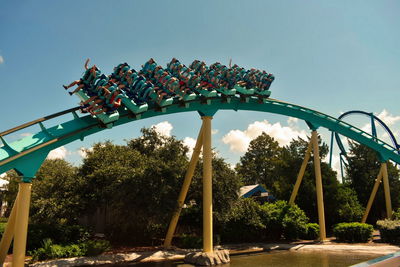 Low angle view of chain swing ride against sky