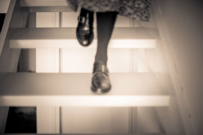 Low section of woman standing on staircase