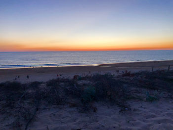 Scenic view of beach against sky during sunset