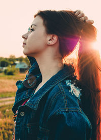 Thoughtful young woman looking away while standing on land