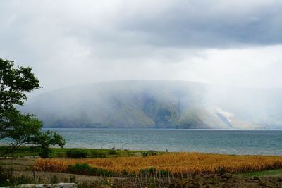 Scenic view of sea and mountains against sky