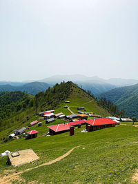 Houses on field against clear sky