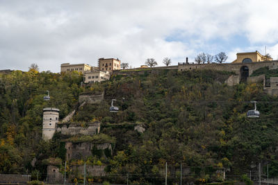 Buildings in town against cloudy sky