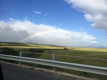 Rainbow over landscape against sky