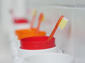 Close-up of toothbrushes in containers at bathroom