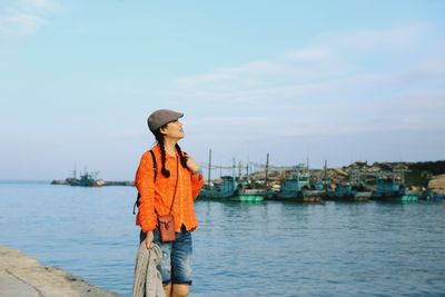 Woman standing at harbor against sky