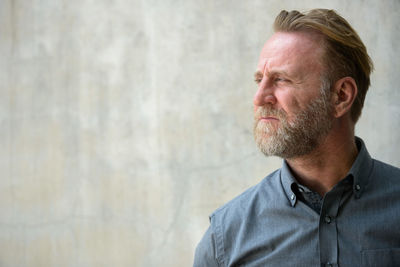 Portrait of man standing against wall