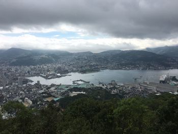 Scenic view of river and town against cloudy sky