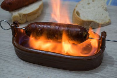 Chorizo al infierno, typical dish of spanish cuisine. chorizo in a clay bowl with alcohol