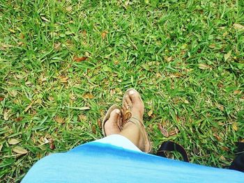 Low section of person relaxing on grassy field