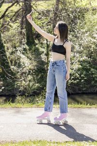 Brunette woman with roller skates taking a selfie