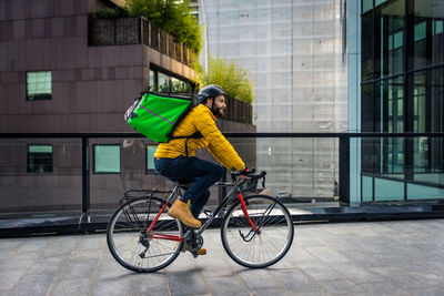 Man riding bicycle on street in city