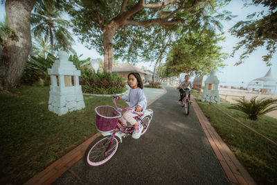 Rear view of man riding bicycle on road