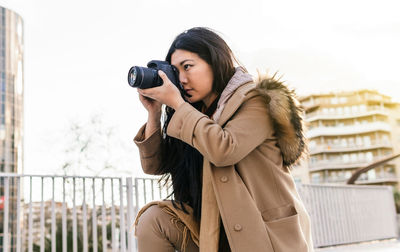 Portrait of woman photographing with camera